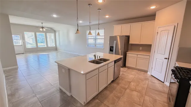 a kitchen that has a sink a refrigerator and window