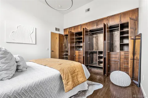 a bedroom with a bed closet and wooden floor