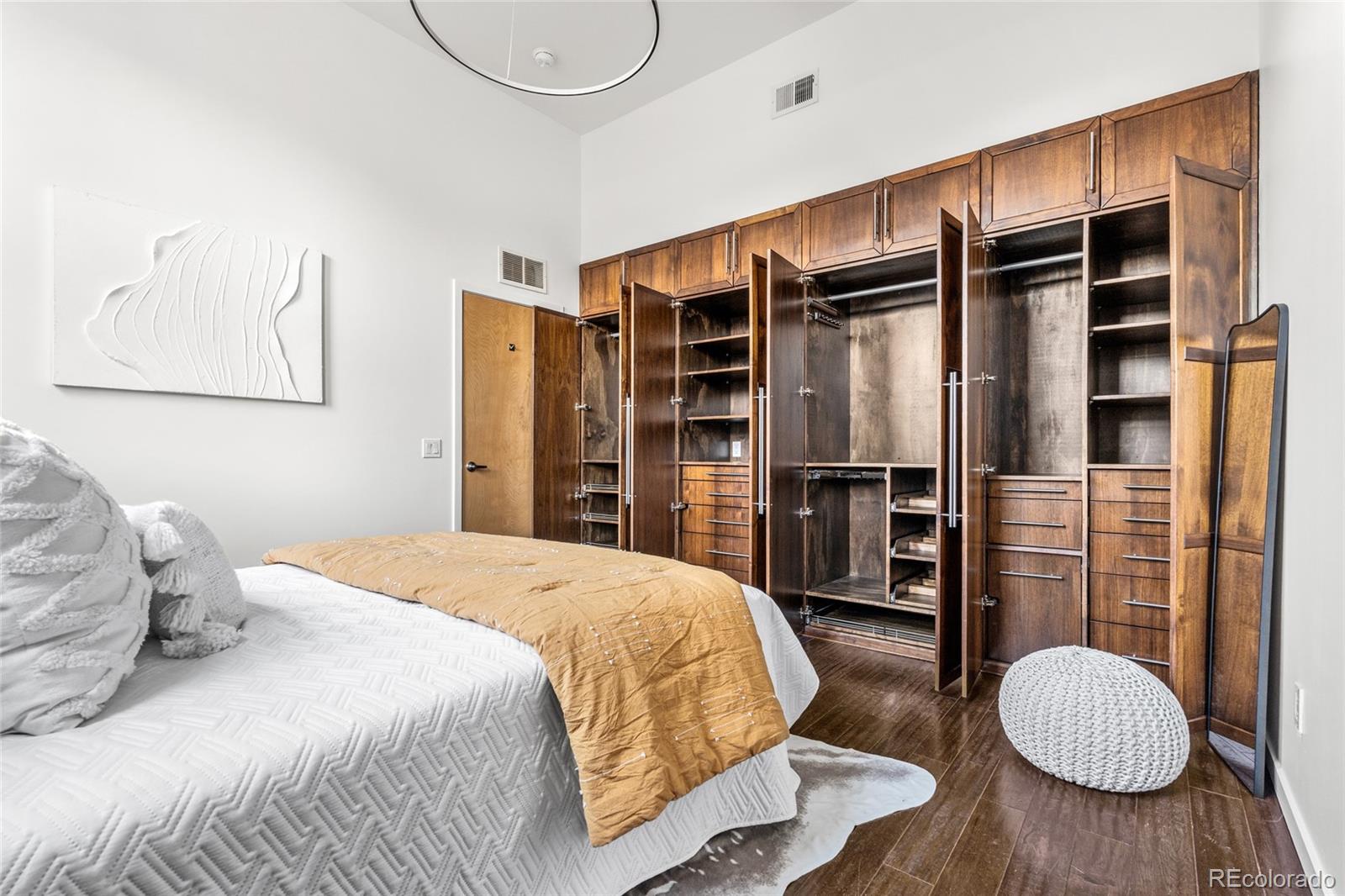 2501 Grove Street, Unit 101 Denver, CO 80211 - Photo 18 of 37 a bedroom with a bed closet and wooden floor