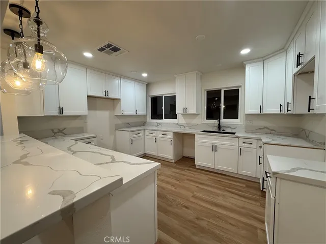 a kitchen with white cabinets appliances and sink