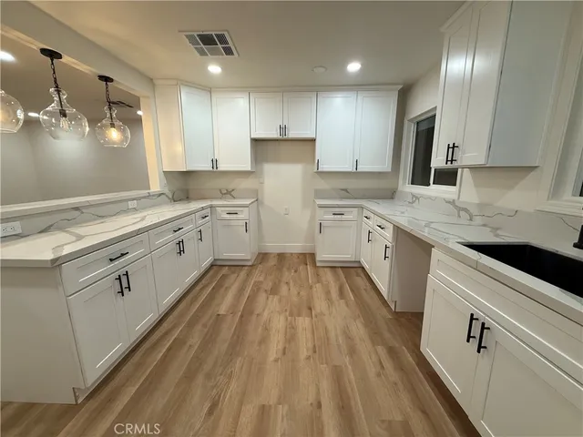 a view of a kitchen with kitchen island a sink stainless steel appliances and cabinets