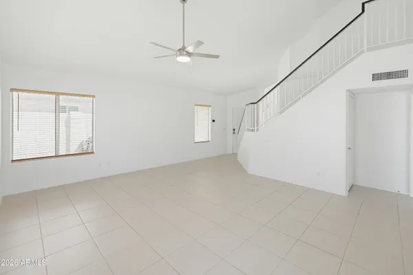 an empty room with a ceiling fan and carpet