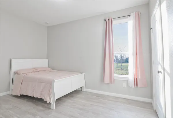 a large bed sitting in a bedroom next to a window