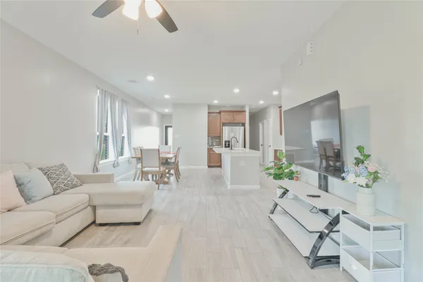 a living room with furniture and a dining table with kitchen view