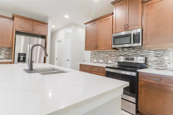 a kitchen with stainless steel appliances granite countertop a stove a sink and a microwave
