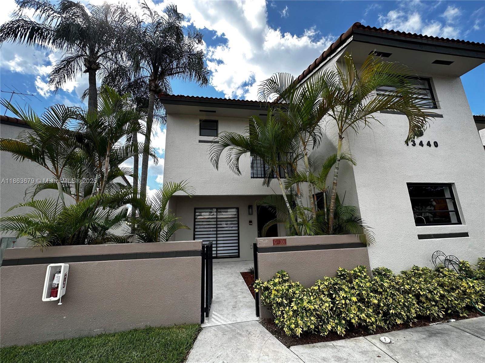 13440 Southwest 62nd Street, Unit G101 Miami, FL 33183 - Photo 1 of 23 a front view of a house with garden