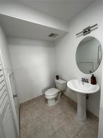 a bathroom with a sink toilet and a mirror