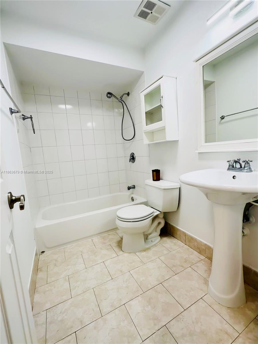 13440 Southwest 62nd Street, Unit G101 Miami, FL 33183 - Photo 18 of 23 a bathroom with a toilet sink and shower