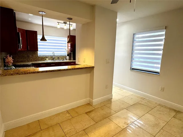 a view of a kitchen with wooden floor and window