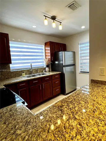 a kitchen with a stove a refrigerator and a sink