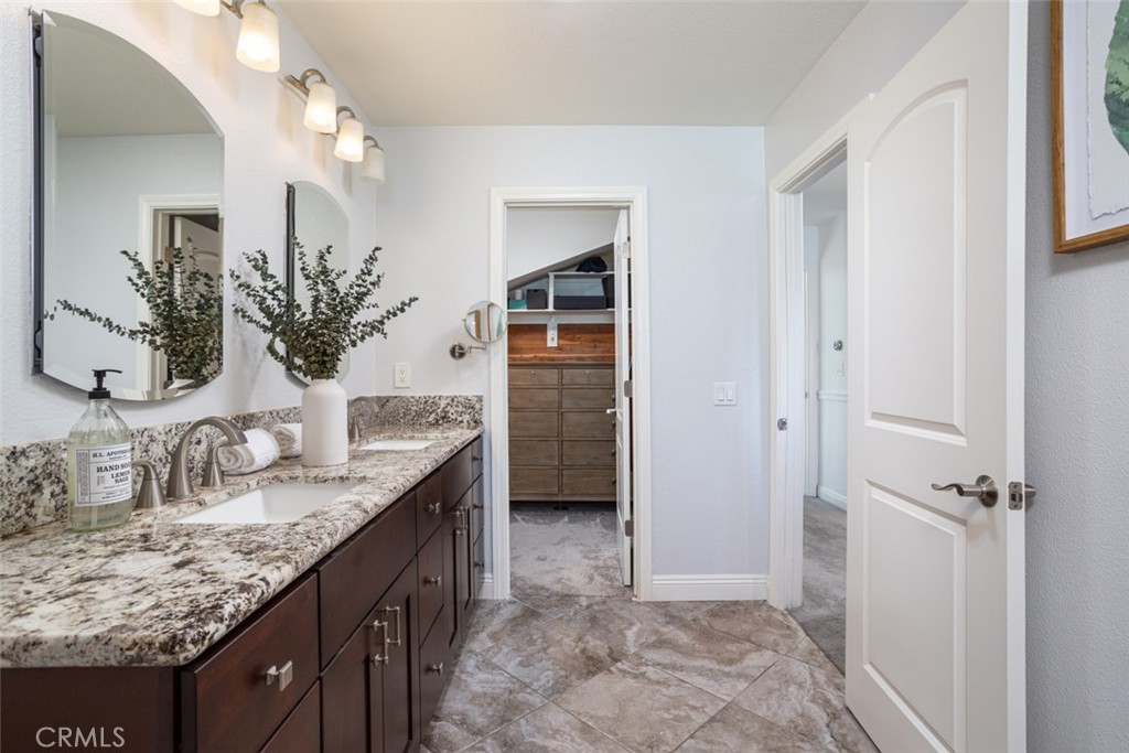2789 Waxwing Circle Costa Mesa, CA 92626 - Photo 23 of 47 a bathroom with a granite countertop sink a mirror and a shower