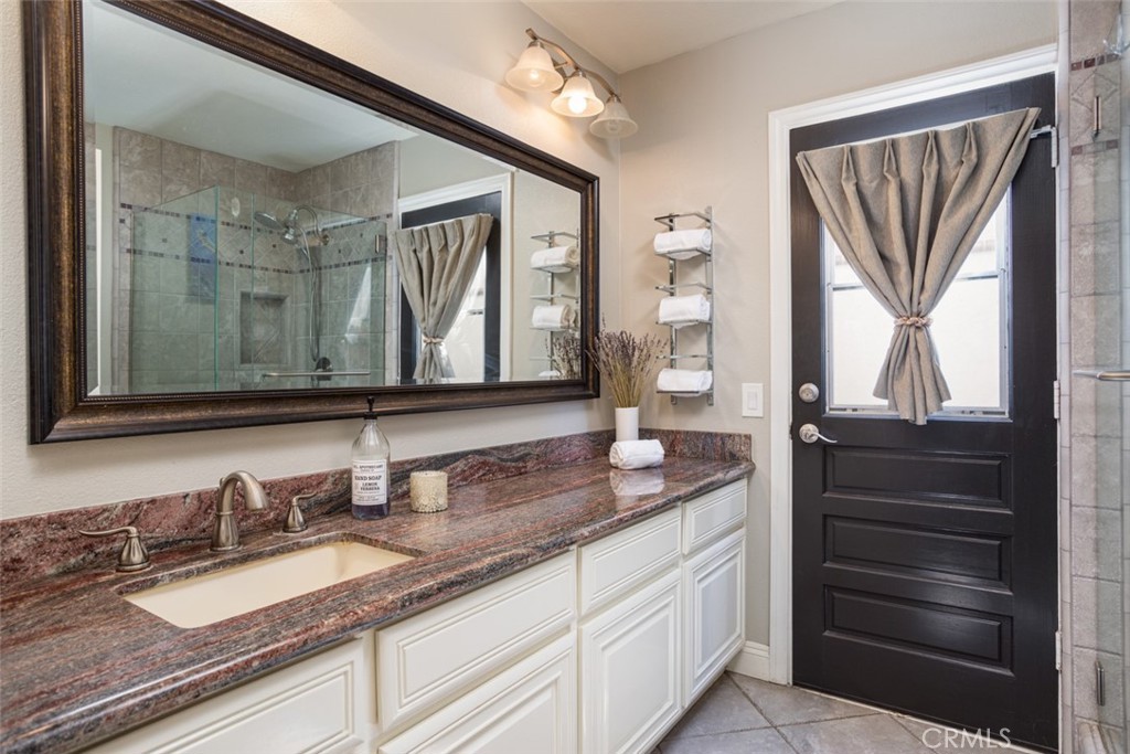 2789 Waxwing Circle Costa Mesa, CA 92626 - Photo 33 of 47 a bathroom with a granite countertop sink and a mirror