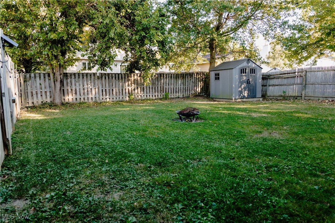 5861 Lee Avenue North Ridgeville, OH 44039 - Photo 20 of 20 Fenced backyard with an outdoor fire pit and a storage unit