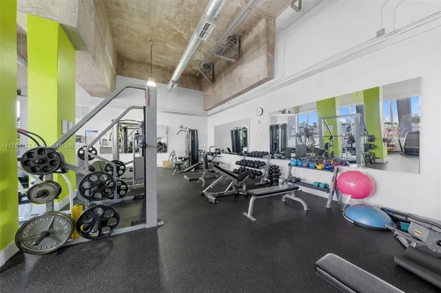 a room with lots of gym equipment and a chandelier