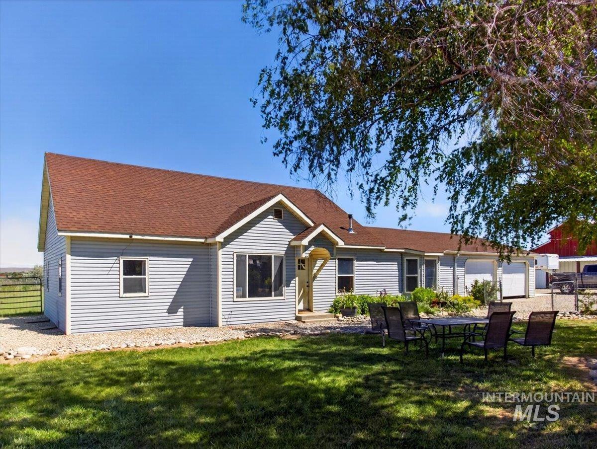 2588 West Sales Yard Road Emmett, ID 83617 - Photo 33 of 49 Light blue siding exterior with a brown shingle roof, featuring a covered front entry and attached garages