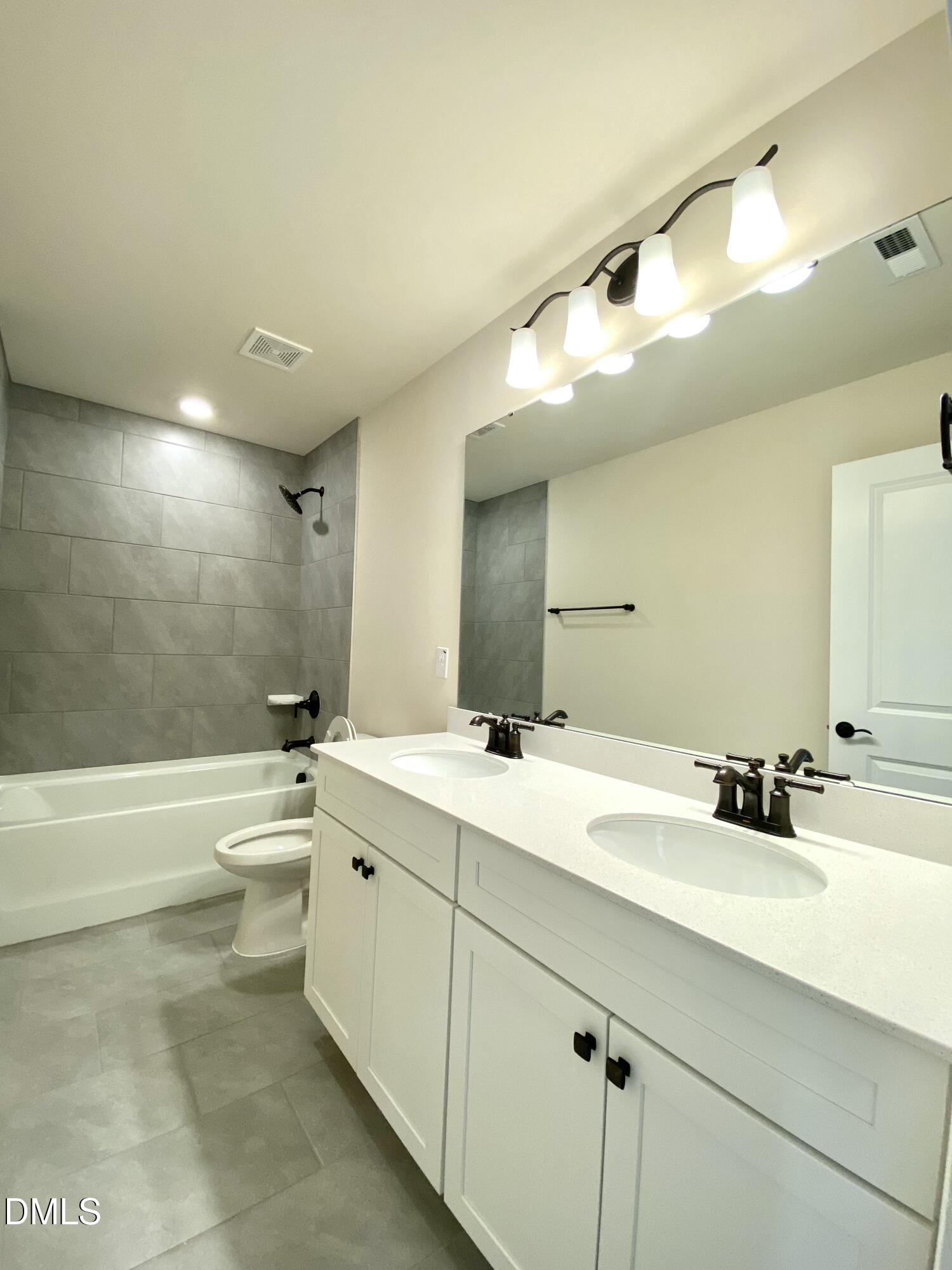 2313 Hedge Maple Drive Raleigh, NC 27603 - Photo 21 of 32 a bathroom with a double vanity sink toilet mirror and bathtub