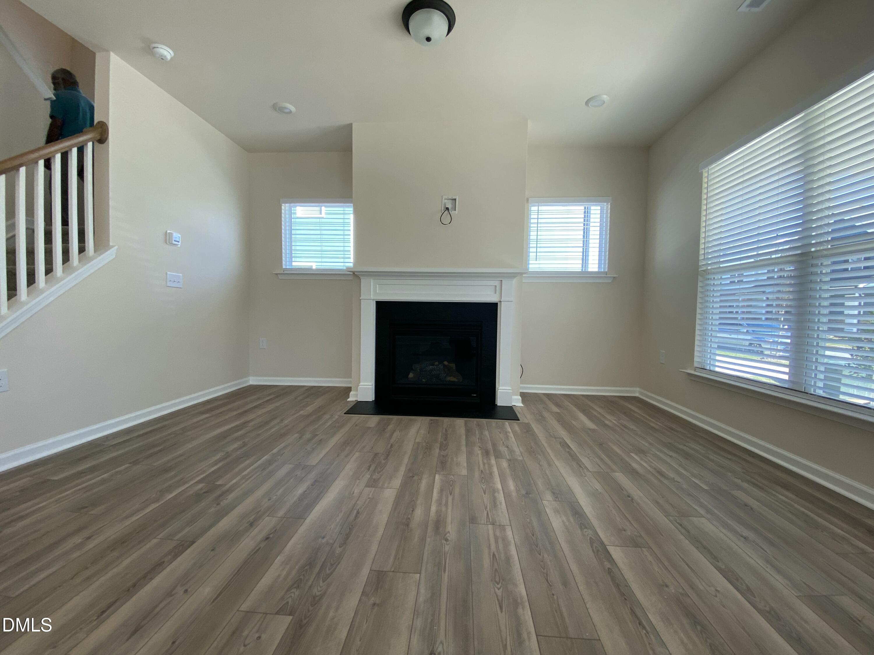 2313 Hedge Maple Drive Raleigh, NC 27603 - Photo 24 of 32 an empty room with wooden floor fireplace and windows