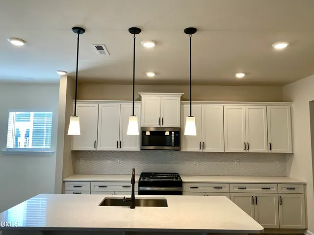 a kitchen with kitchen island a counter top space appliances and cabinets