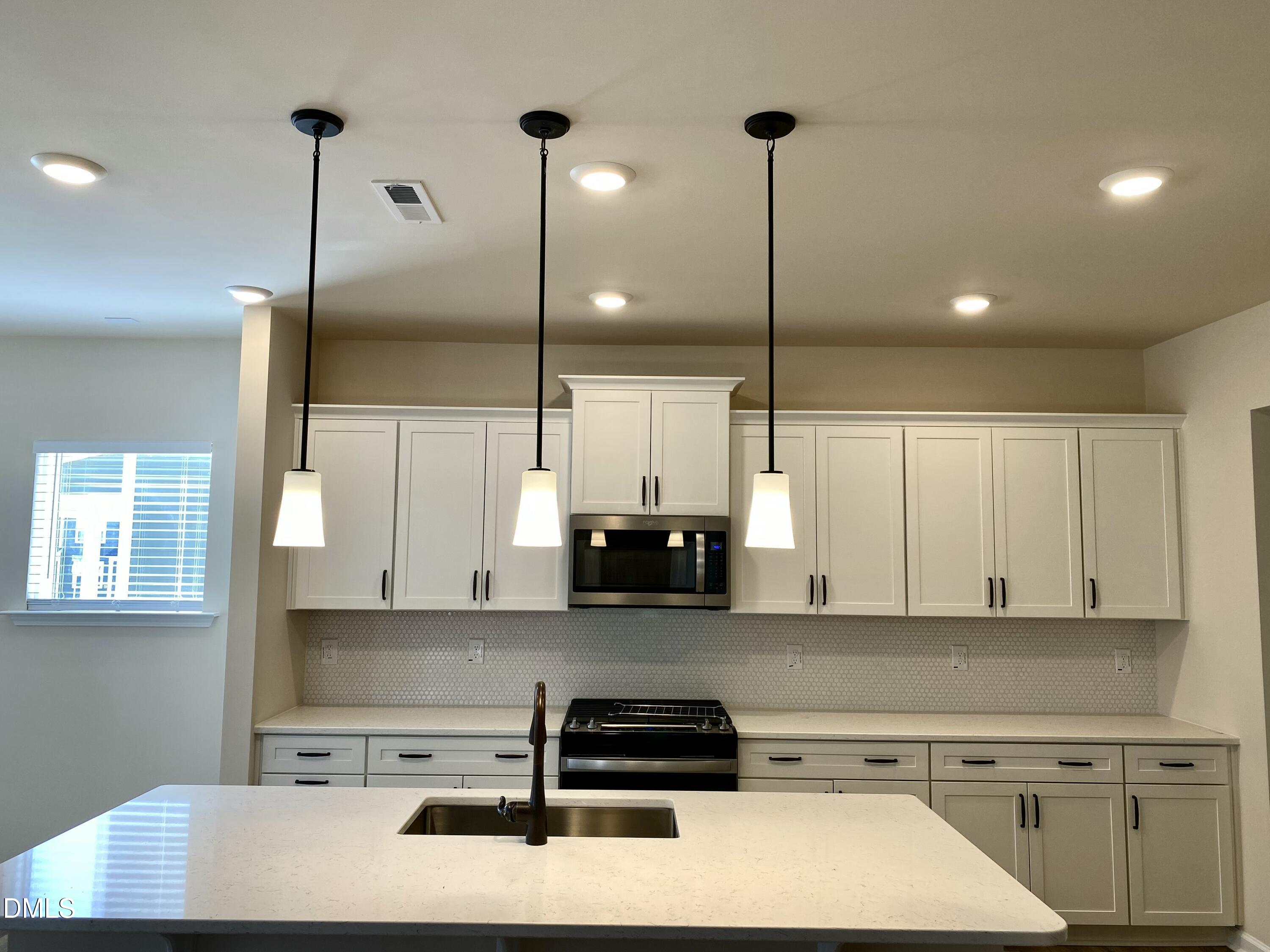2313 Hedge Maple Drive Raleigh, NC 27603 - Photo 5 of 32 a kitchen with kitchen island a counter top space appliances and cabinets