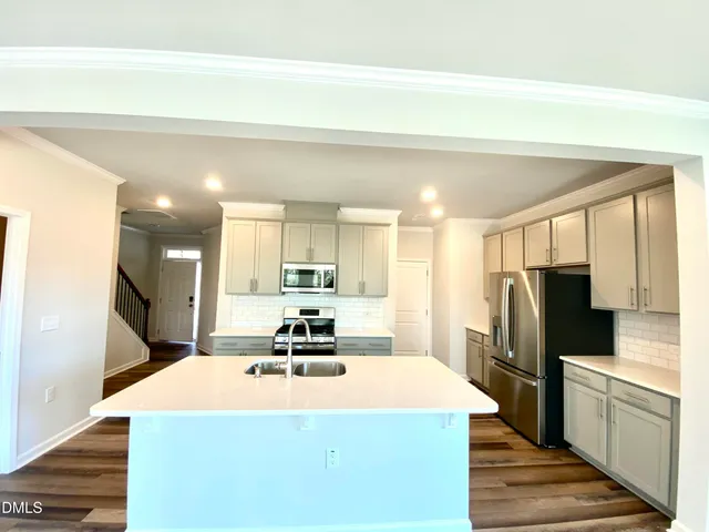 a kitchen with stainless steel appliances a refrigerator sink and microwave