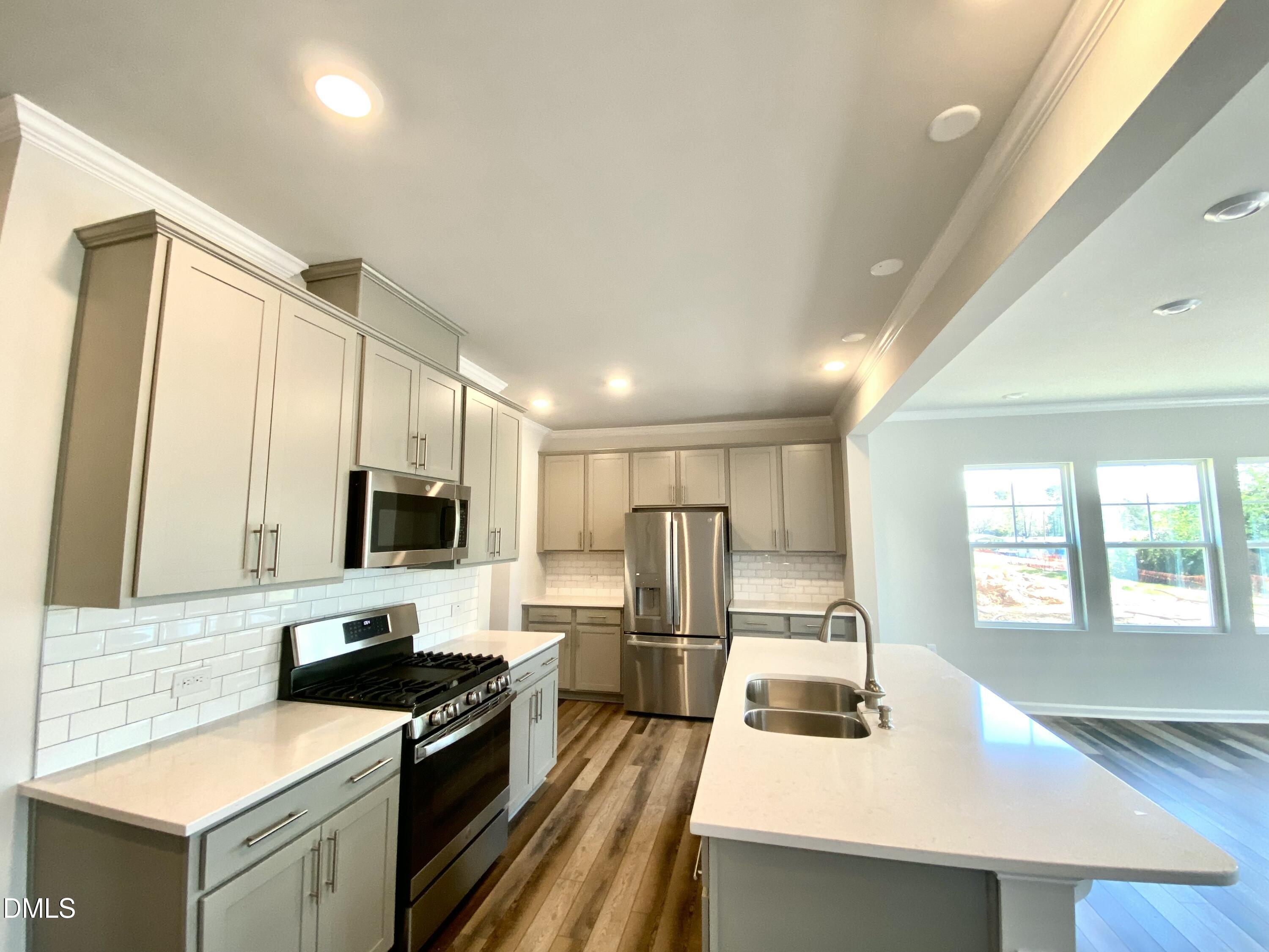 2313 Hedge Maple Drive Raleigh, NC 27603 - Photo 9 of 32 a kitchen with a sink a counter top space stainless steel appliances cabinets and a counter top space