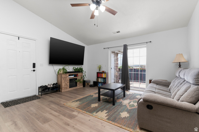 25 West Ridge Road, Unit 25 Saratoga Springs, UT 84045 - Photo 1 of 22 Living area featuring vaulted ceilings, wood-finish flooring, a ceiling fan with light, and a glass sliding door opening to an exterior space