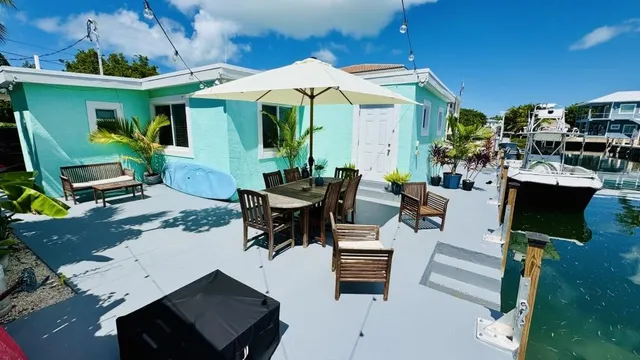a view of a patio with dining table and chairs under an umbrella