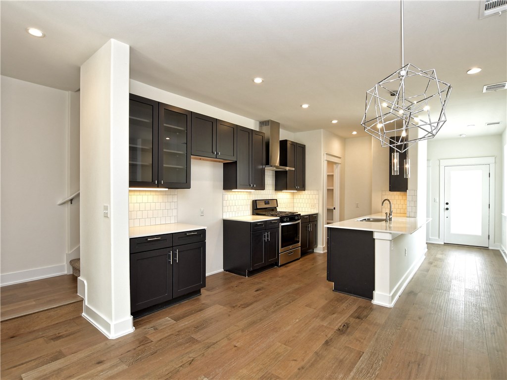a large kitchen with stainless steel appliances kitchen island granite countertop a stove top oven and sink