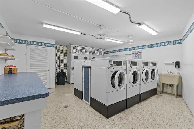 a utility room with stainless steel appliances lots of white cabinets