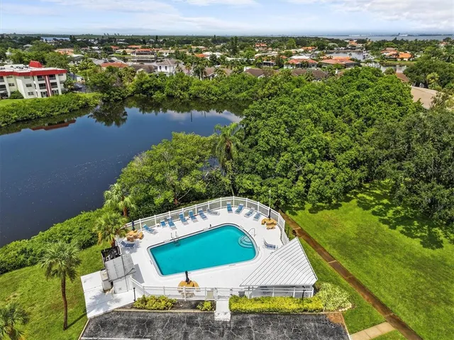 an aerial view of a house with a yard and lake view