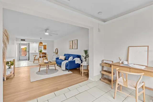 a living room with furniture a wooden floor and next to a window