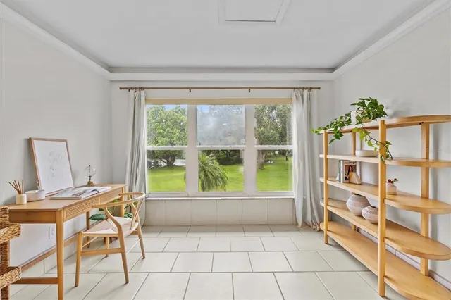 a view of a workspace with furniture and a window
