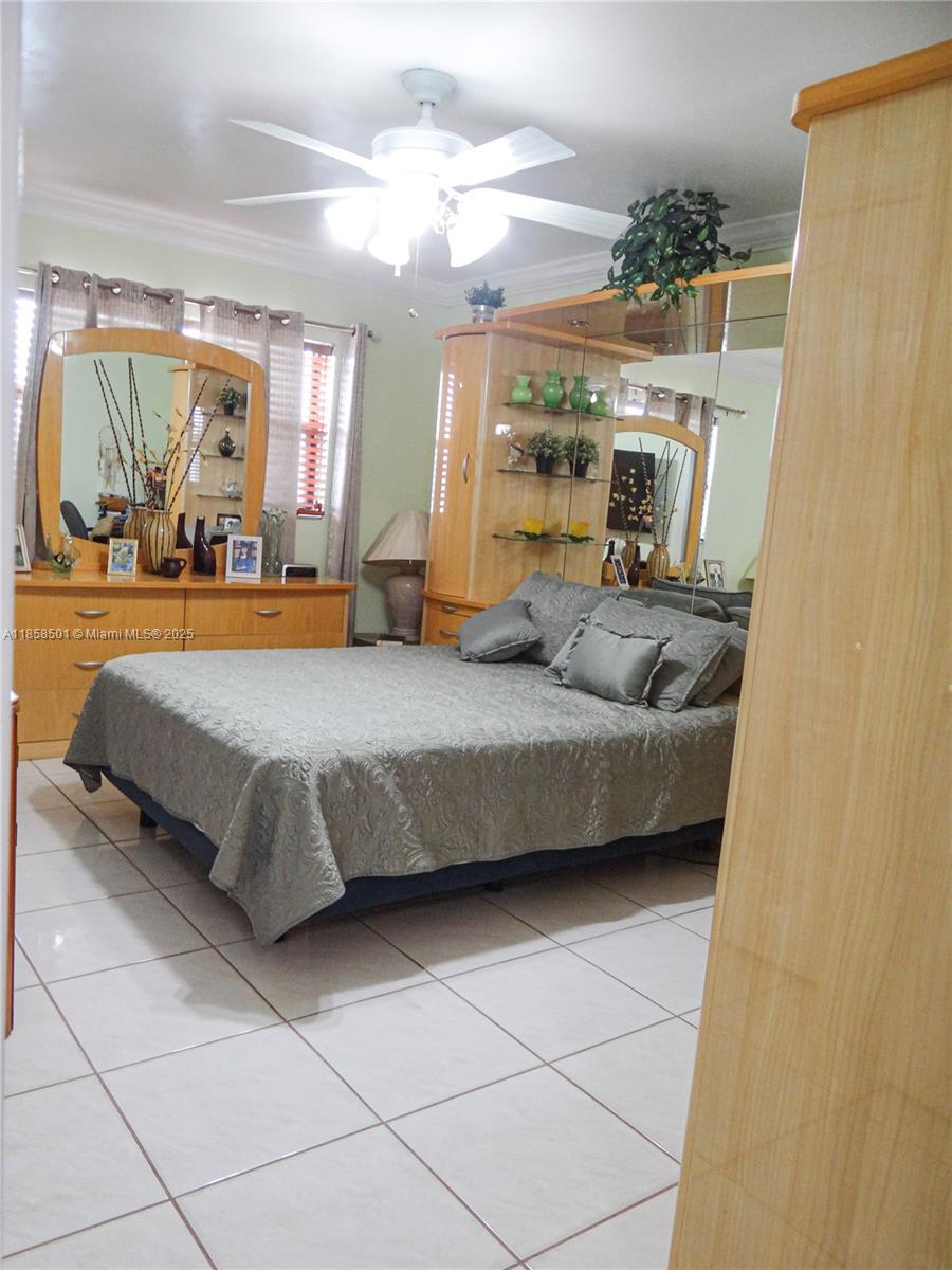 1800 West 54th Street, Unit 309 Hialeah, FL 33012 - Photo 11 of 19 a bedroom with a large bed and a chandelier