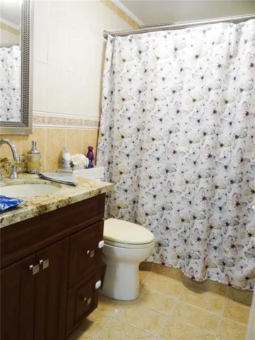 a bathroom with a granite countertop sink a toilet and a mirror