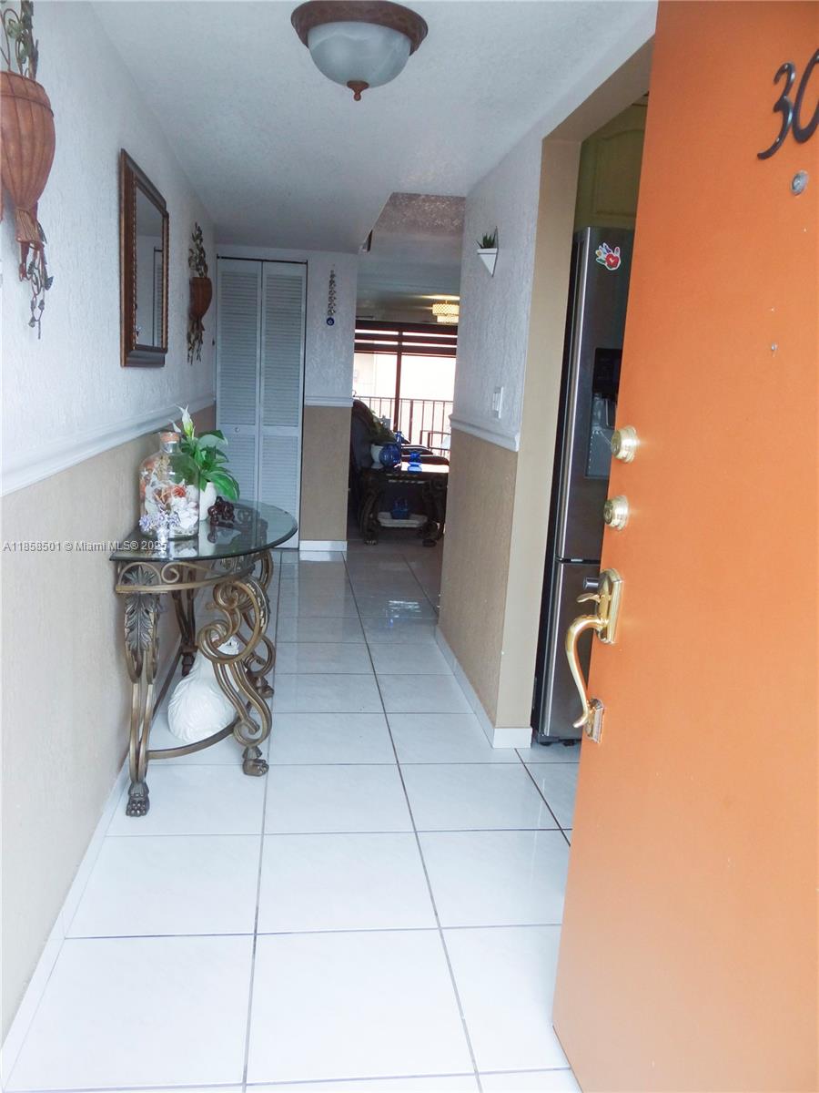 1800 West 54th Street, Unit 309 Hialeah, FL 33012 - Photo 3 of 19 a dining room with furniture and a chandelier