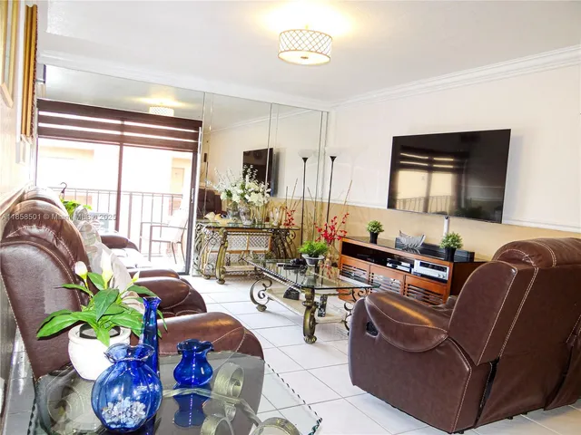 a living room with furniture potted plant and a large window