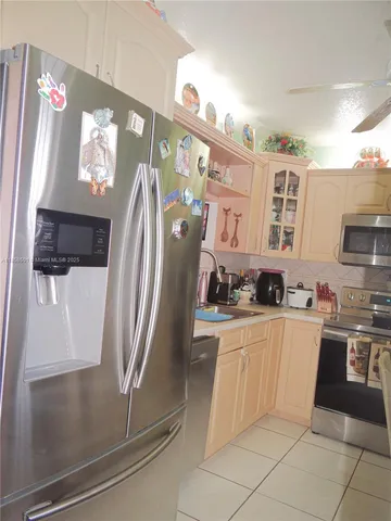 a kitchen with stainless steel appliances granite countertop a refrigerator and a stove