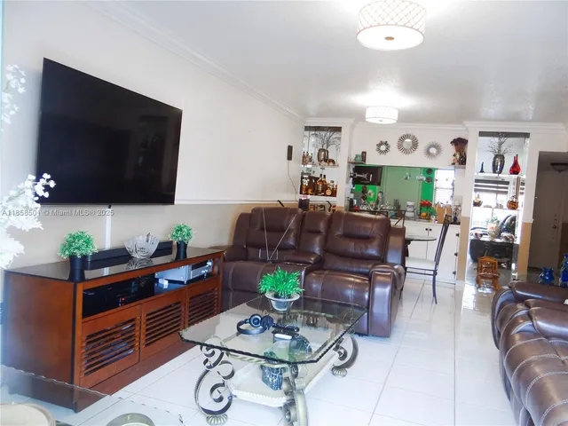 a living room with furniture a flat screen tv and a dining table