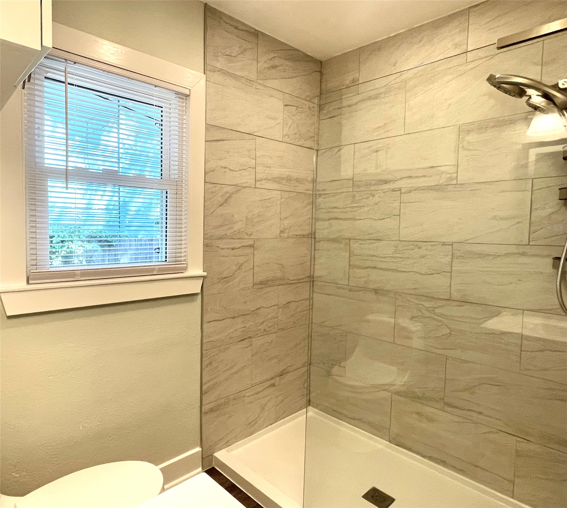 807 East Riverside Drive, Unit B Austin, TX 78704 - Photo 17 of 28 A sleek, tiled walk-in shower and well-lit window create a refreshed bathing experience.