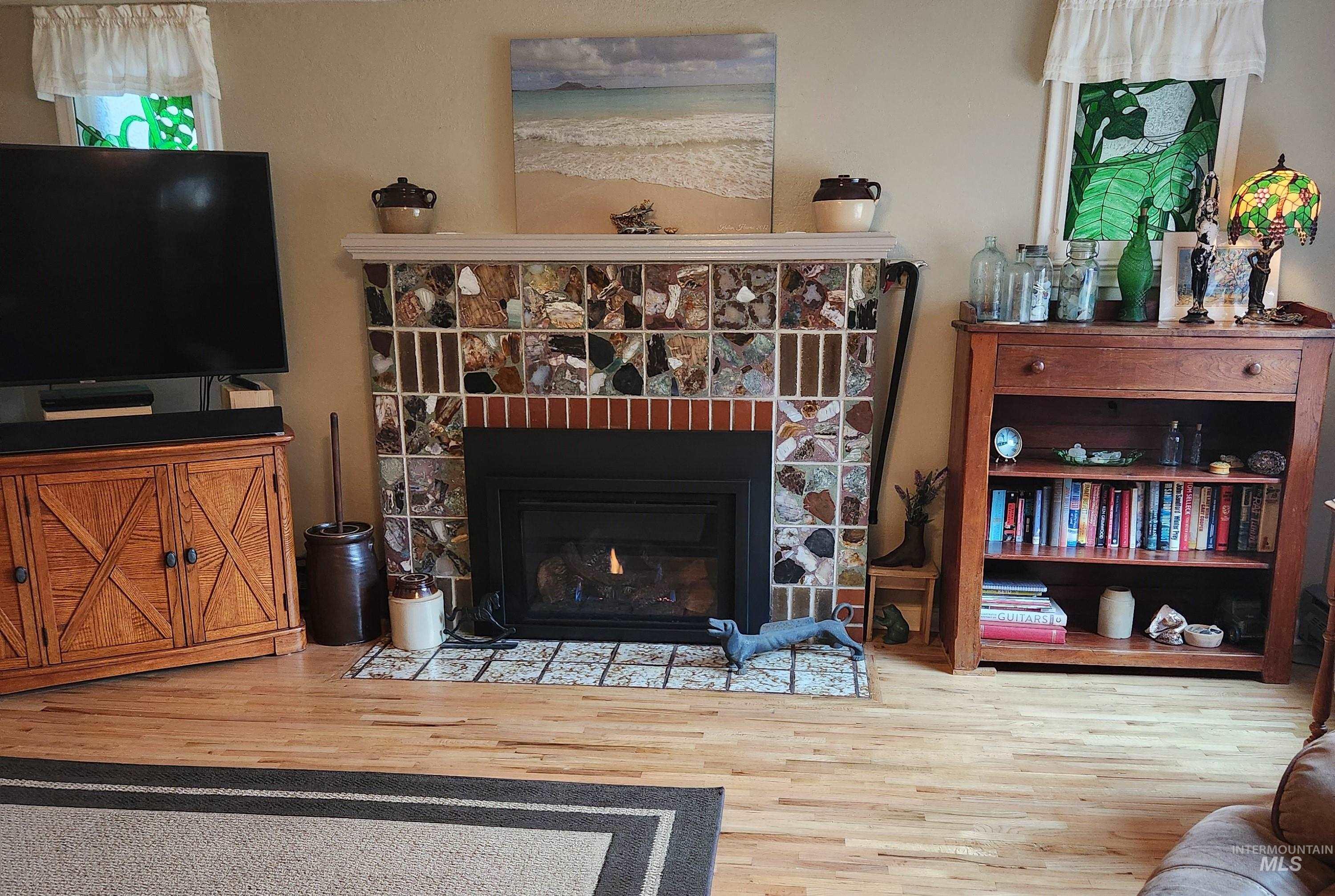 1105 Nevada Street Gooding, ID 83330 - Photo 14 of 26 Living room featuring wood finished floors and a stone fireplace