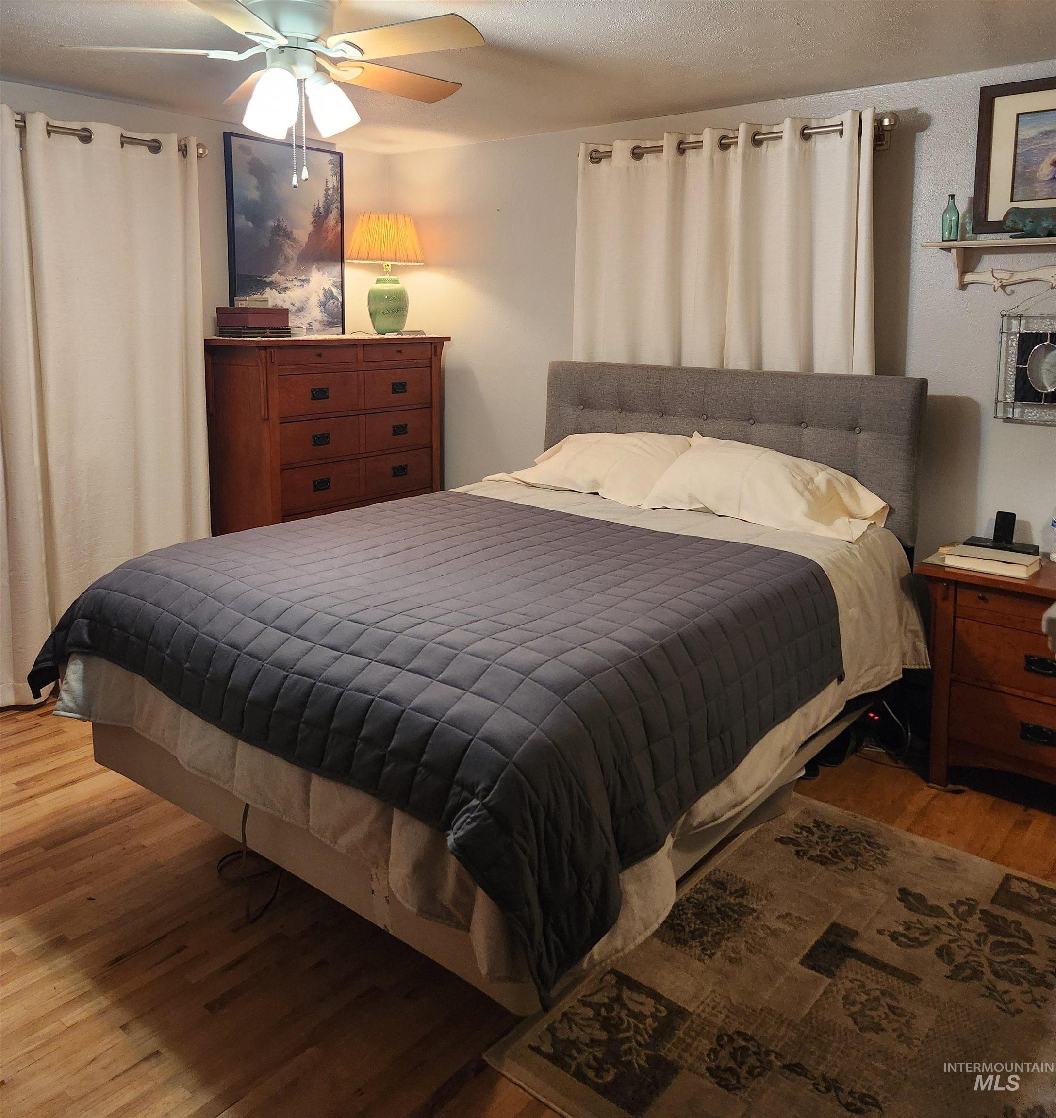 1105 Nevada Street Gooding, ID 83330 - Photo 15 of 26 Bedroom with wood finished floors, a ceiling fan, and a textured ceiling