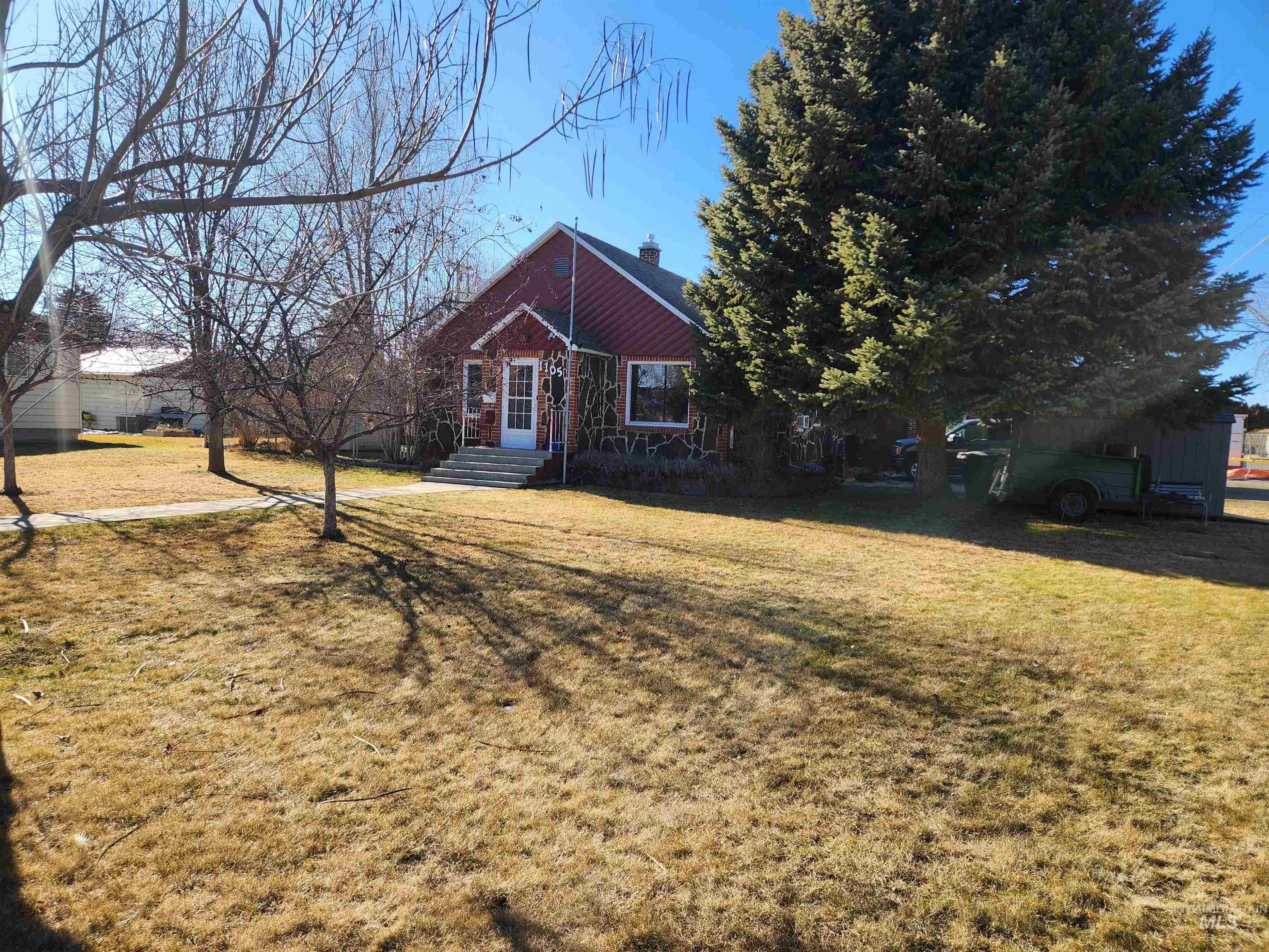 1105 Nevada Street Gooding, ID 83330 - Photo 2 of 26 View of front of home featuring a front yard and a chimney