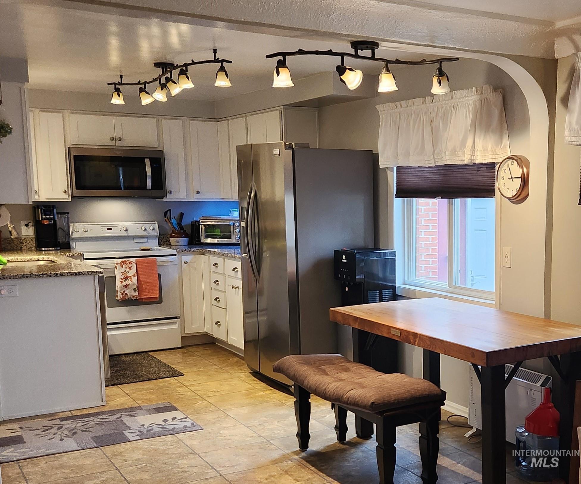 1105 Nevada Street Gooding, ID 83330 - Photo 10 of 26 Kitchen with white cabinetry, stainless steel appliances, and dark stone counters