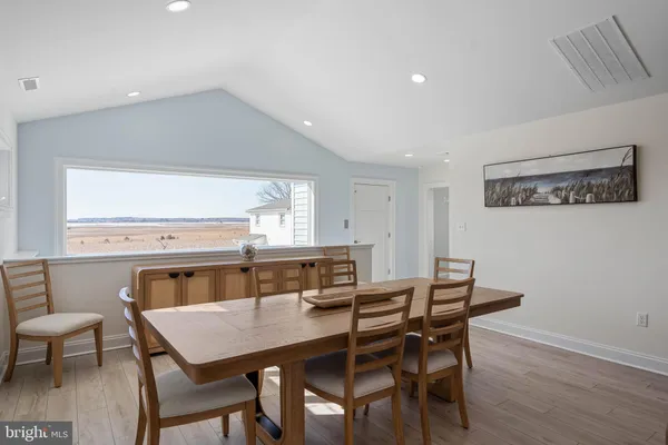 a kitchen with stainless steel appliances granite countertop a sink a stove a refrigerator cabinets and chairs