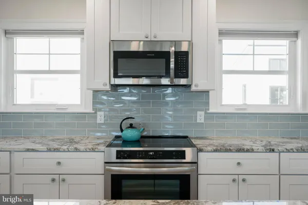 a kitchen with granite countertop white cabinets and white appliances
