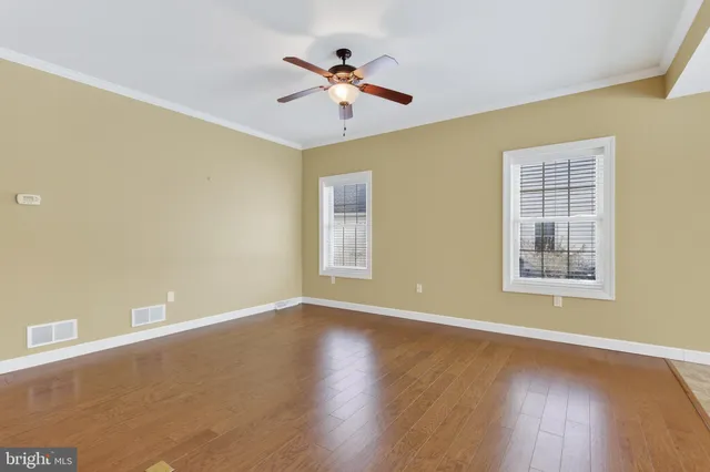 a view of wooden floor and a chandelier fan in a room