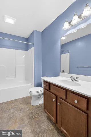 a bathroom with a granite countertop sink toilet a large mirror and bathtub