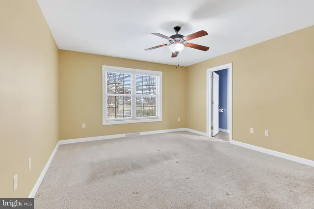an empty room with a chandelier fan and a ceiling fan