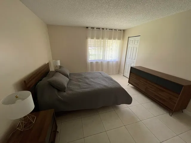 a bedroom with a bed chair and window