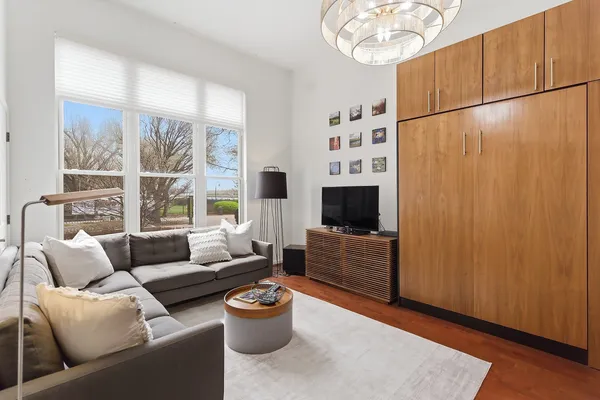 a living room with furniture a flat screen tv and a large window